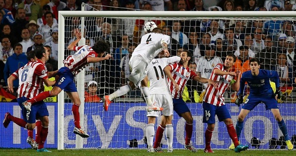 Real Madrid's Sergio Ramos (C) shoots and scores the first goal for the team during their Champions League final soccer match against Atletico Madrid at the Luz Stadium in Lisbon May 24, 2014. REUTERS/Paul Hanna (PORTUGAL - Tags: SPORT SOCCER TPX IMAGES OF THE DAY)